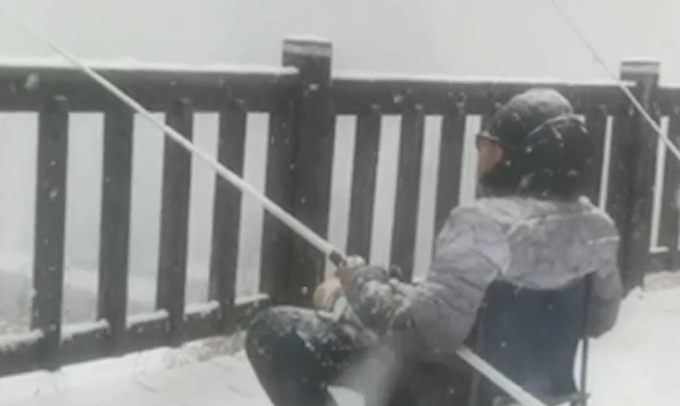 大连男子冒大雪桥边钓鱼 网友：看着真冷！咋不戴个手套？